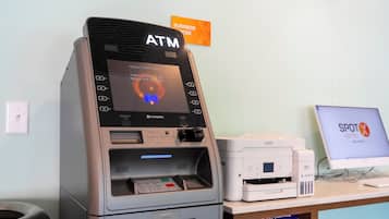 Um caixa automático com abertura para recibos, dispensador de dinheiro e leitor de cartão.