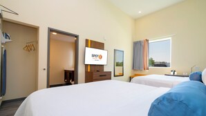 A hotel room with two beds, a TV, a wardrobe, and a window with curtains. - SPOT X Hotel Orlando/Intl Dr by The Red Collection (Orlando)