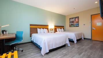 Een hotelkamer met twee bedden, een bureau met stoel en een aan de muur hangend kunstwerk.