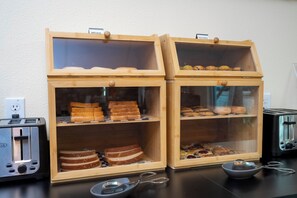 Two wooden display cases with glass fronts, each containing various baked goods. - SPOT X Hotel Orlando/Intl Dr by The Red Collection (Orlando)