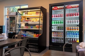 Zona de venta automática de bebidas con diversas opciones, incluyendo gaseosas, jugos y agua.