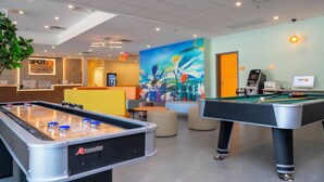 A hotel lobby with a pool table, a foosball table, and a reception desk. - SPOT X Hotel Orlando/Intl Dr by The Red Collection (Orlando)