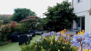 A garden with outdoor seating and a variety of plants and flowers. - Villa 12 pers : 6 bedrooms, 3 bathrooms, 3wc/ 200m from the beach of La Sauzaie (Bretignolles-sur-Mer)