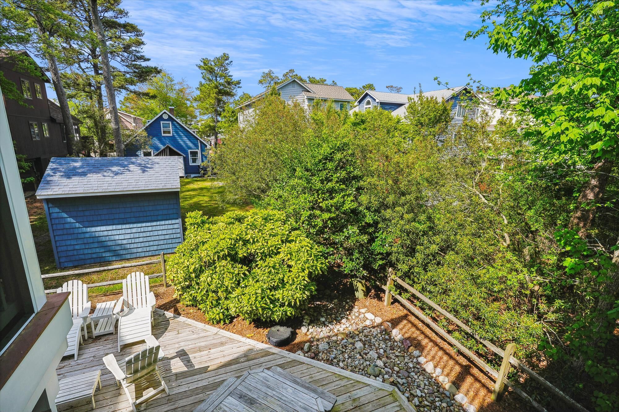 A deck with outdoor seating and a small shed.