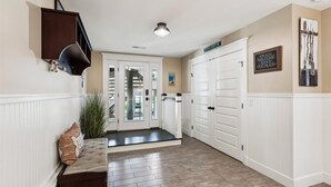A hallway with a white door, a bench, and a plant. - 221 Wellington Parkway (Bethany Beach)