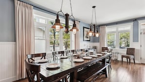 A dining area with a long wooden table set for six, surrounded by dark wooden chairs. - 221 Wellington Parkway (Bethany Beach)