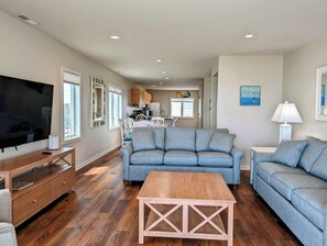289A 38901 Bunting Avenue Living Room with Light Blue Seating an - A bright living area featuring two light blue sofas, a wooden coffee table, and a large flat-screen TV mounted above a matching wood console. - Oceanfront 5BR Duplex in Fenwick Island – Direct Beach Access & Stunning Views (Fenwick Island)