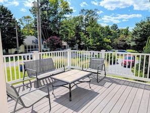 A deck with outdoor furniture and a white fence.