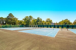 An outdoor tennis court with a net, surrounded by trees and a fence. - 511 Doral Drive - Bethany West (Bethany Beach)