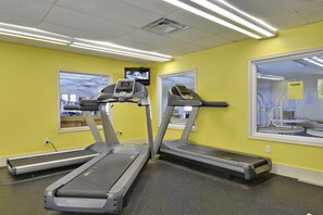 A gym with treadmills, a television, and a window with a view of the outside. - 511 Doral Drive - Bethany West (Bethany Beach)