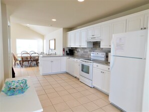 6 South Carolina Avenue - Gourmet Kitchen - The bright kitchen features crisp white cabinetry, modern stone countertops, and full-sized appliances. Tile flooring and an open-concept design make this space as practical as it is stylish for beachside cooking.