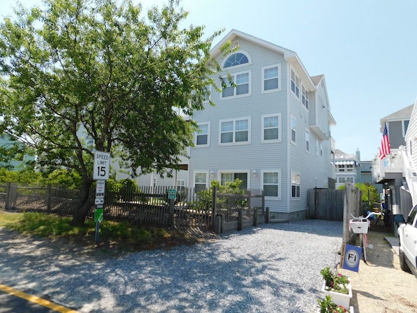 6 South Carolina Avenue - Side Yard and Exterior Profile - Mature trees and fencing wrap around the property, offering a sense of seclusion in the heart of Fenwick Island. The home's light-colored siding and traditional beach-style architecture blend perfectly with the surrounding coastal neighborhood.