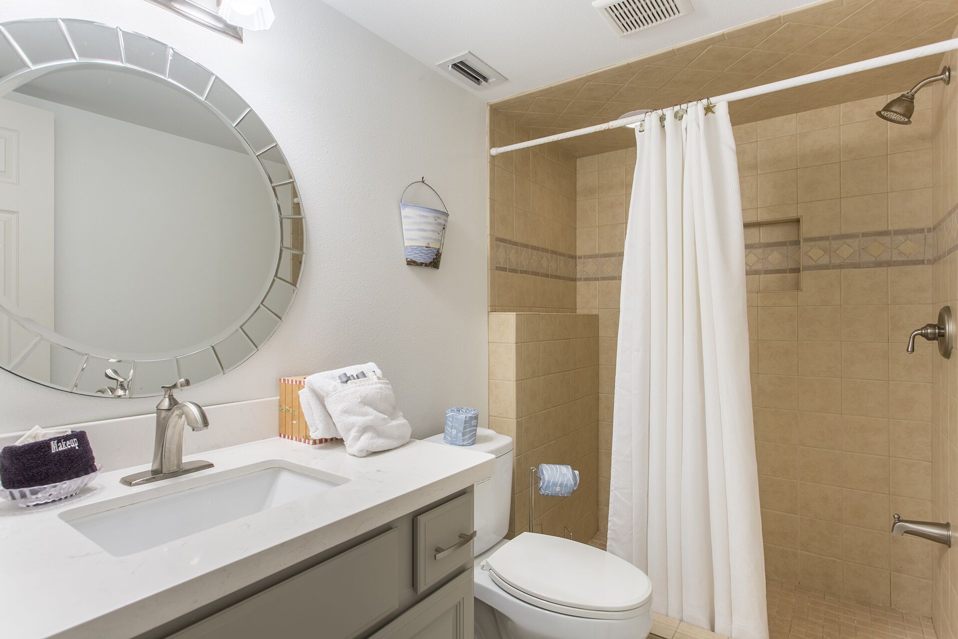 Une salle de bain équipée d’un lavabo, d’un miroir, de toilettes et d’une douche.