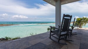 A covered outdoor seating area with a view of the ocean. - Always Calm Beach. No Estate like this in Exuma! Brand New on protected sand bar (Little Exuma, Exuma)