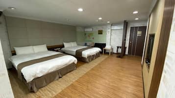 Een hotelkamer met twee bedden, een tafeltje en een kledingkast.