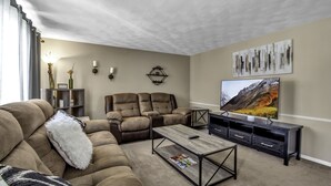 A living room with a sectional sofa, a recliner, a coffee table, and a TV on a stand. - Quiet suburban home 10 minutes from airport/25 min from Niagara Falls (Depew)