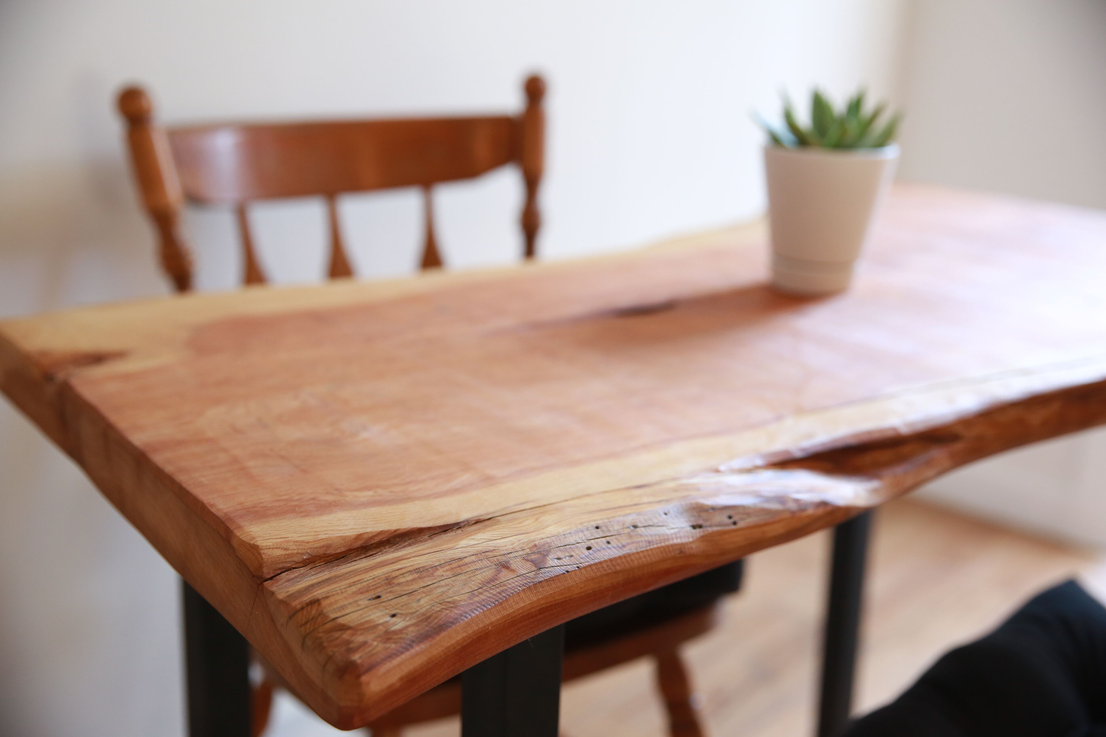 A wooden table with a potted plant on it.