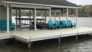 A covered dock with seating and a boat.