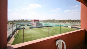A view from a balcony overlooking a sports field with fencing and a small building in the distance. - Zahoui Garden Marrakech 4761 (Marrakech)