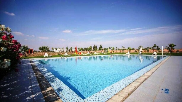A rectangular swimming pool with clear blue water, surrounded by a tiled deck. - Zahoui Garden Marrakech 4761 (Marrakech)