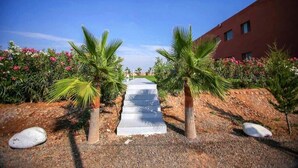 A pathway flanked by palm trees leading to a building with a red facade. - Zahoui Garden Marrakech 4761 (Marrakech)