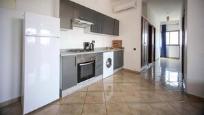 A kitchen with a refrigerator, oven, washing machine, and grey cabinets. - Zahoui Garden Marrakech 4761 (Marrakech)