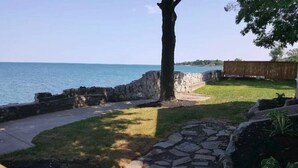 Un sentier de pierres qui mène à une zone herbeuse offrant une vue sur la mer.