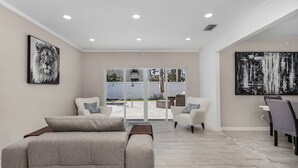 A modern living room with a sofa, armchairs, and a dining area. - Downtown Retreat (Fort Myers)