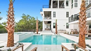 A modern two-story building with a swimming pool, palm trees, and outdoor seating. - 169 Lakeview Drive (Santa Rosa Beach)