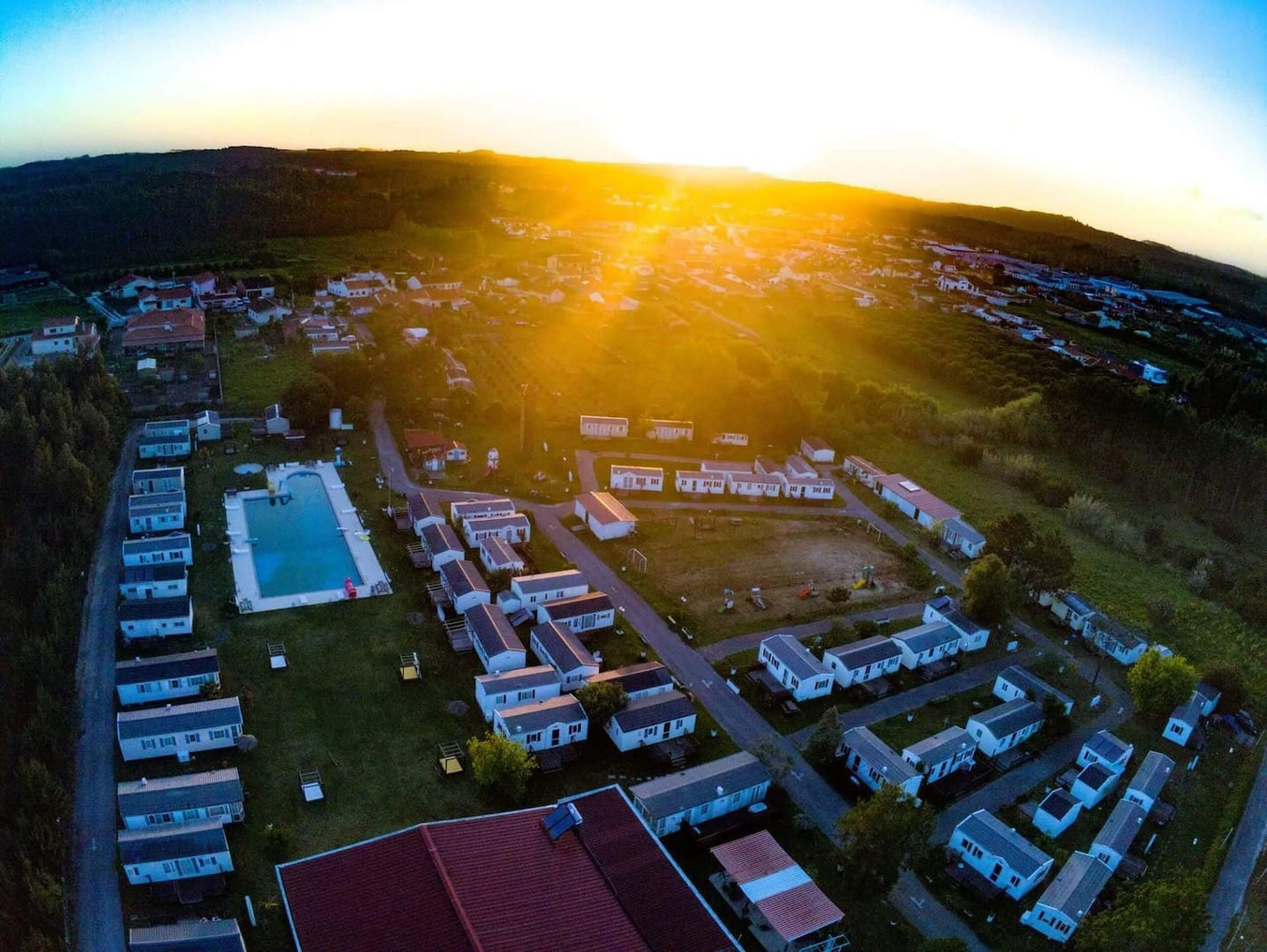 An aerial view of a residential area with multiple houses and a swimming pool.