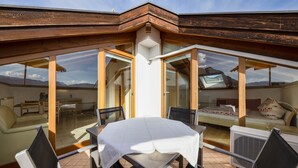 Un comedor con mesa y sillas, un sofá y una cama con vistas a las montañas.