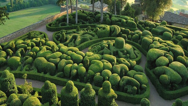 A meticulously landscaped garden with geometric hedges and a stone pathway. - Cottage in Vézac near Forest and Lake (Vezac)