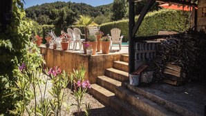 A rustic outdoor seating area with potted plants, a wooden pergola, and a sign reading "Les Copains". - Cottage in Vézac near Forest and Lake (Vezac)