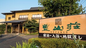 Ein traditionelles japanisches Gebäude mit einem Schild, das den Namen 'HOZANSO' und einige japanische Schriftzeichen zeigt.