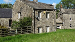 A stone building with multiple windows and a wooden fence in front. - The Smithy (Richmond)