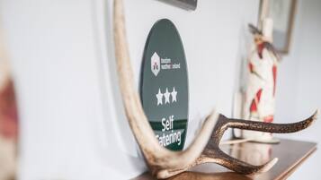 Un senyal d'allotjament amb servei de cuina equipada, un logotip i text que indica turisme a Irlanda del Nord.