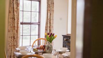 A dining table set with plates, bowls, and a vase with tulips.