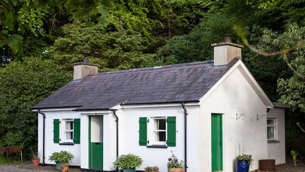 A white house with green shutters and a grey roof, surrounded by trees. - Mr Mcgregors' Cottage (Omagh)