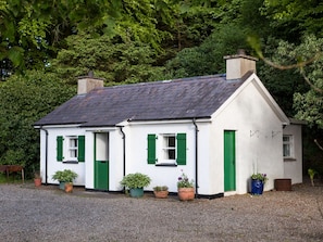 A white house with green shutters and a grey roof, surrounded by trees. - Mr Mcgregors' Cottage (Omagh)