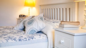 A bedroom with a bed, pillows, a bedside table, and a lamp. - Mr Mcgregors' Cottage (Omagh)
