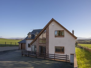 A two-story house with a sloped roof, large windows, and a brick exterior. - Dol Fraint (Gaerwen)