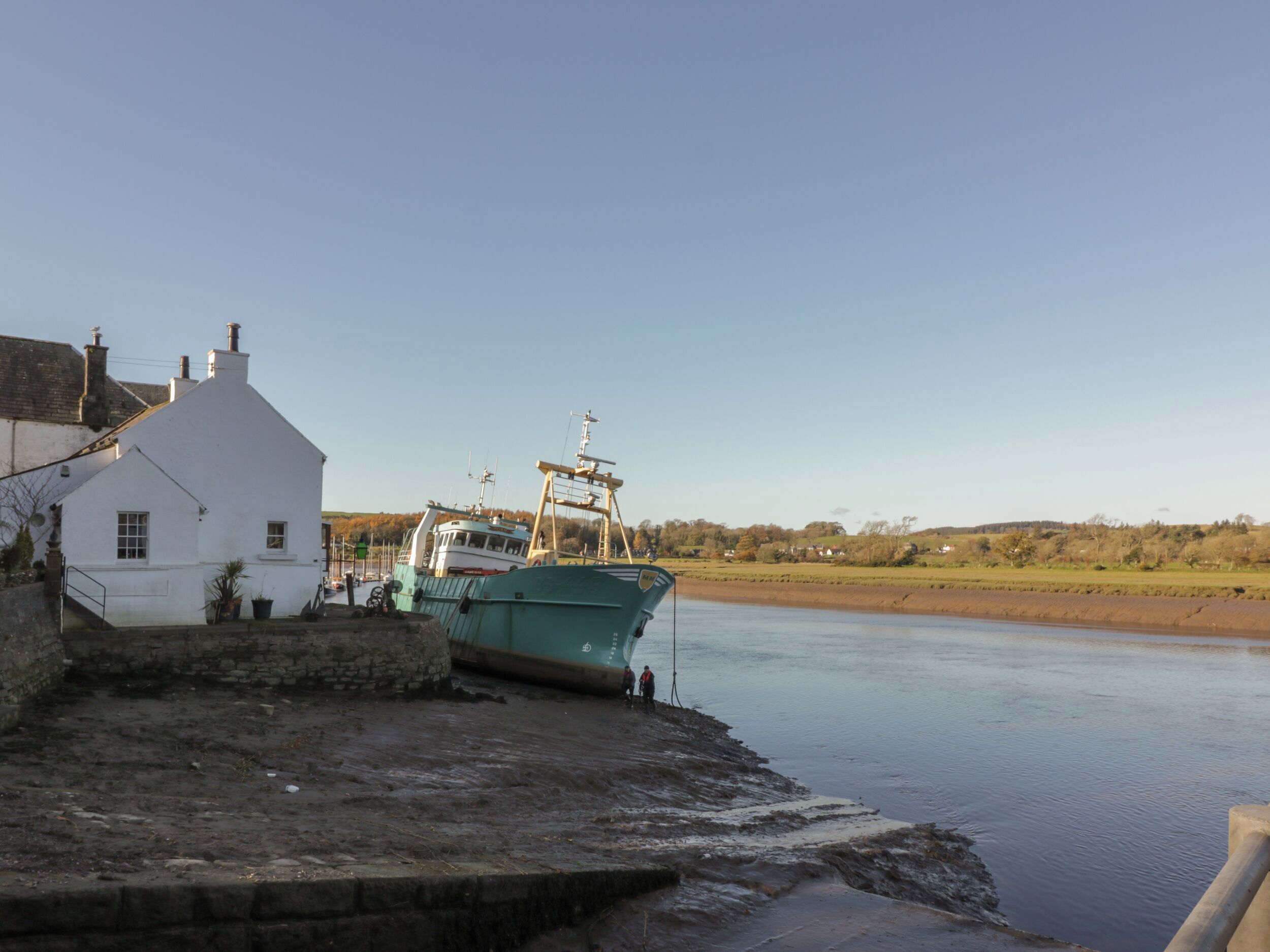 A white building with a dock and a boat.