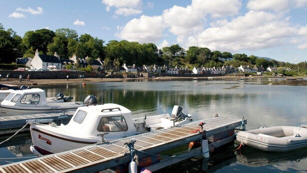 A marina with boats docked, a wooden pier, and houses in the background. - Craggan Cottage - Balmacara (Kyle)