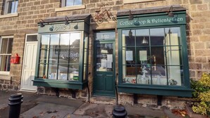 A two-story stone building with a coffee shop and a deli on the ground floor. - 3 Springhaven (Godalming)