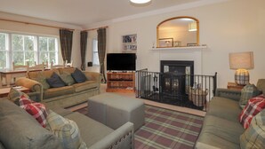 A living room with a fireplace, a television, and a sofa set. - Inverewe - Garden Lodge (Achnasheen)