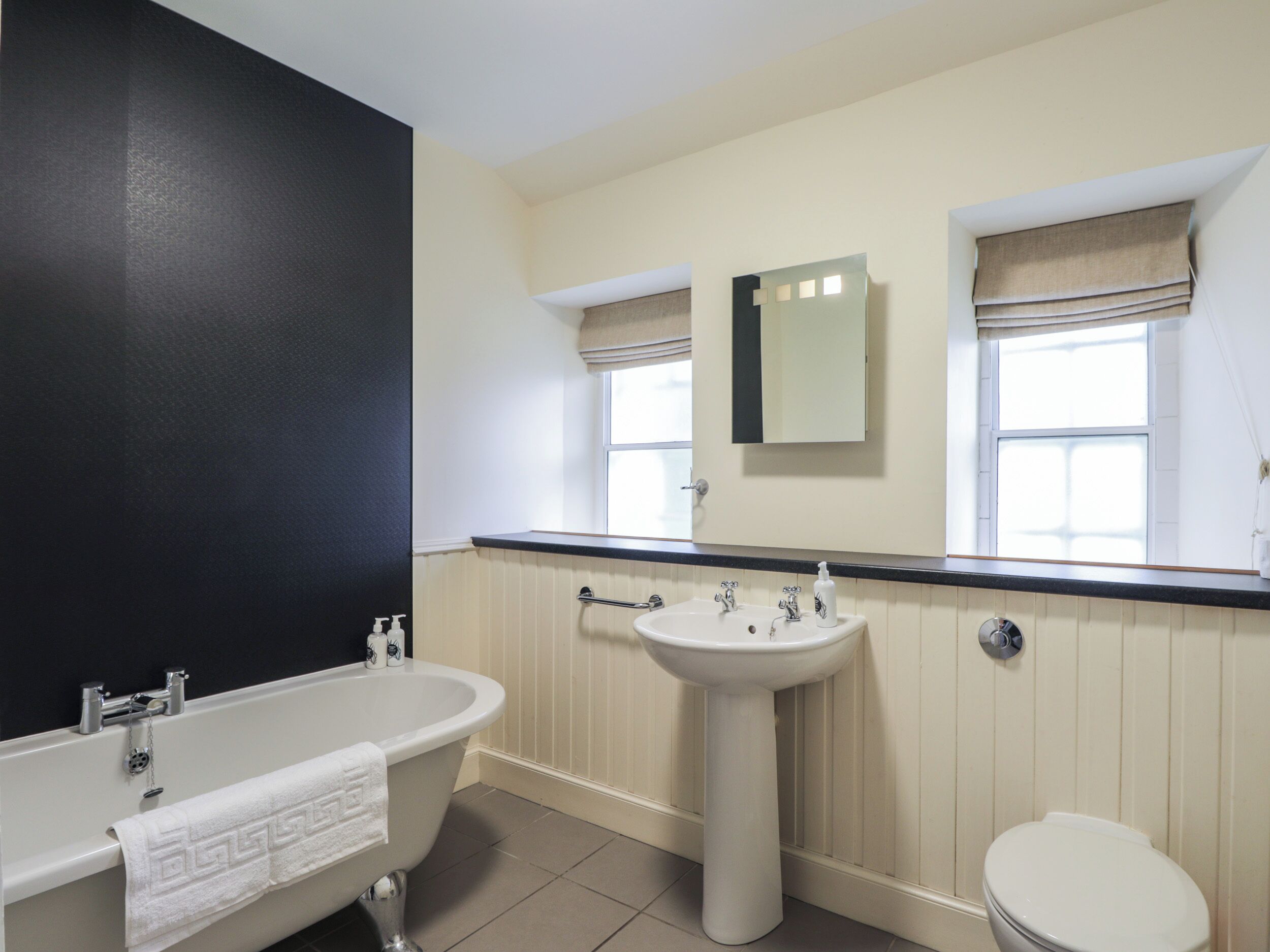 A bathroom with a bathtub, sink, and toilet.