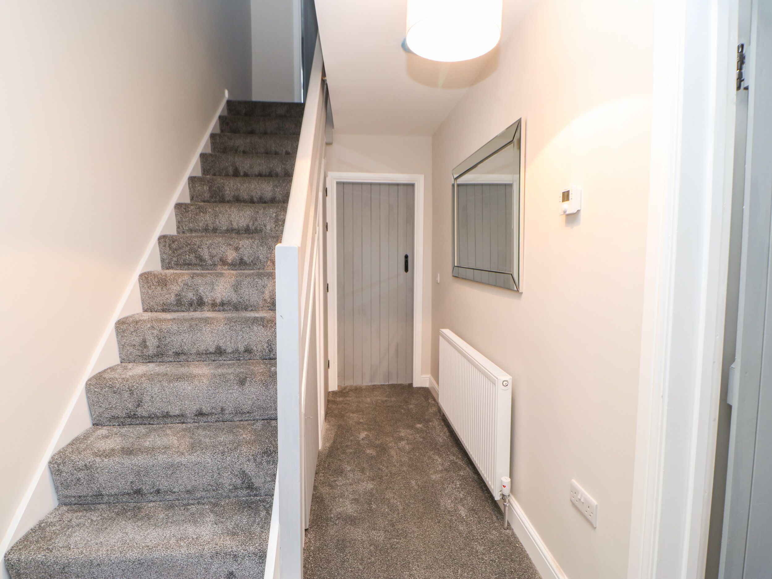 A staircase with carpeted steps leading to a door.