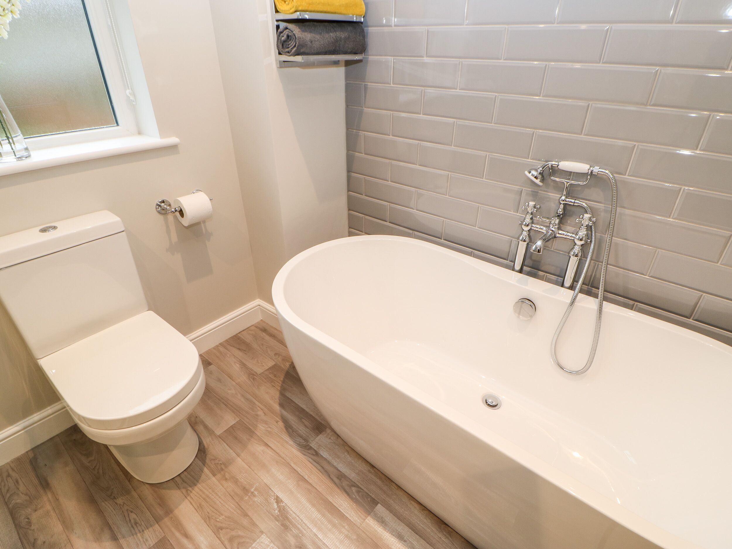 Ein Badezimmer mit Toilette, Badewanne und Fenster.