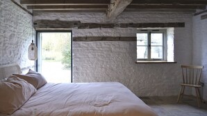 Una camera da letto con un letto, una finestra e una sedia.