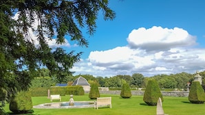 A well-maintained garden with neatly trimmed hedges, a stone fountain, and a gazebo. - Beechgrove Cottage - Pitmedden Gardens (Ellon)